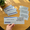 Set of four retro computer loading bar birthday cards with slide-out message inserts on a wooden table.