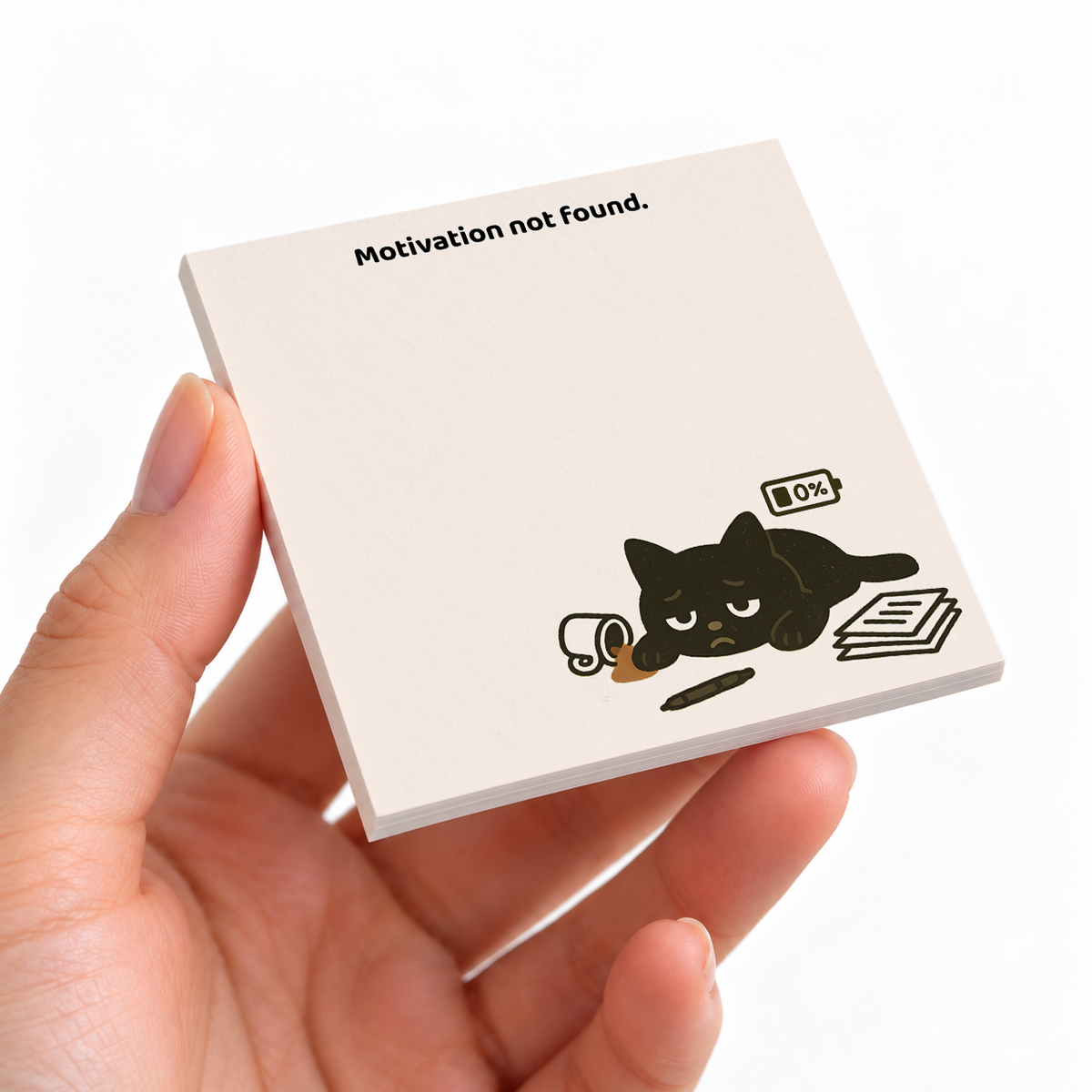 Motivation Not Found Black Cat sticky note pad on a desk with stationery