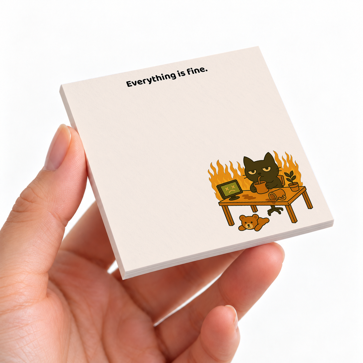 Everything Is Fine Fire Cat sticky note pad on a desk with stationery