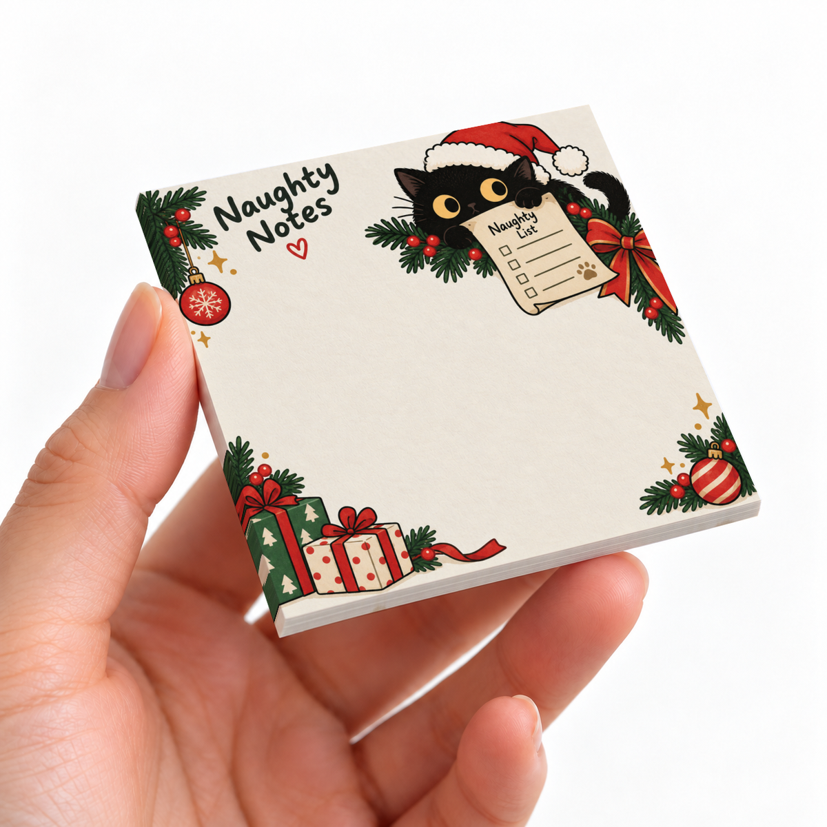 Hand holding a Santa Cat Naughty Notes sticky note pad with a black cat, gifts, ornaments, and blank writing space.