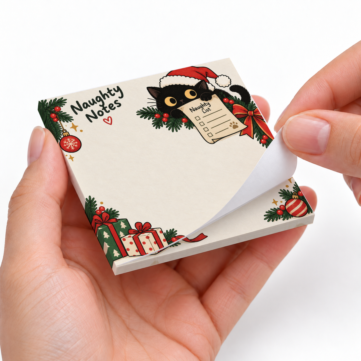 Hands peel a sheet from the Santa Cat Naughty Notes sticky note pad, featuring a black cat in a Santa hat.
