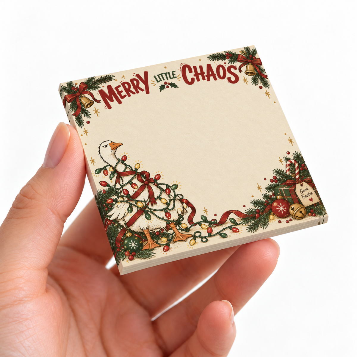 Hand holding a Christmas sticky note pad with a goose tangled in lights and “Merry Little Chaos” lettering.
