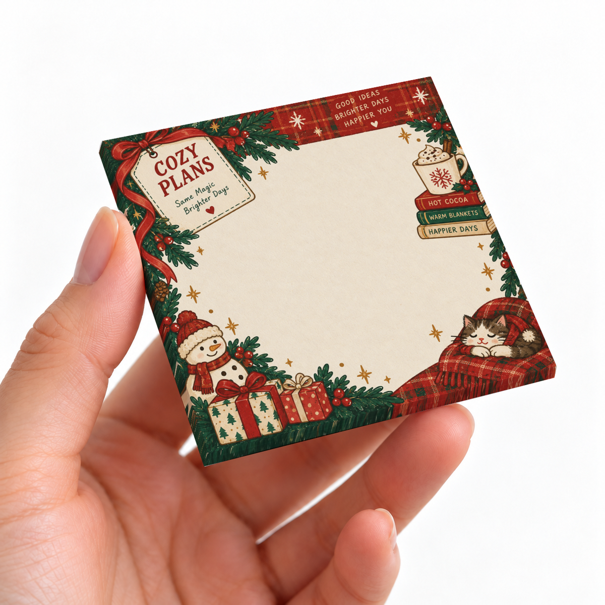 Hand holding a Christmas sticky note pad with a cozy cat, cocoa, snowman, gifts, and evergreen border.