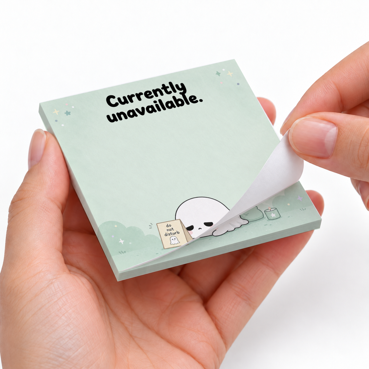 Hands peel a sheet from mint Sleepy Ghost sticky notes featuring a resting ghost and “Currently unavailable.”