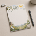 This Is The Day Psalm 118 memo pad featuring a floral landscape and cross, placed on a beige desk with a pen and eraser.