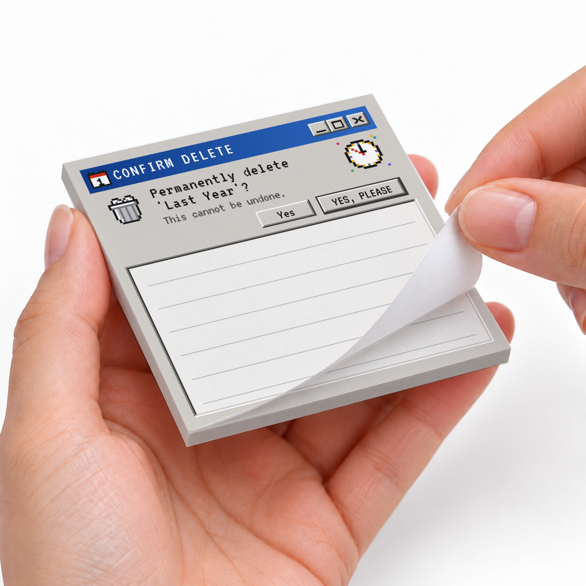 Hands peel a sheet from a retro computer sticky note pad reading “Permanently delete ‘Last Year’?” above lined space.