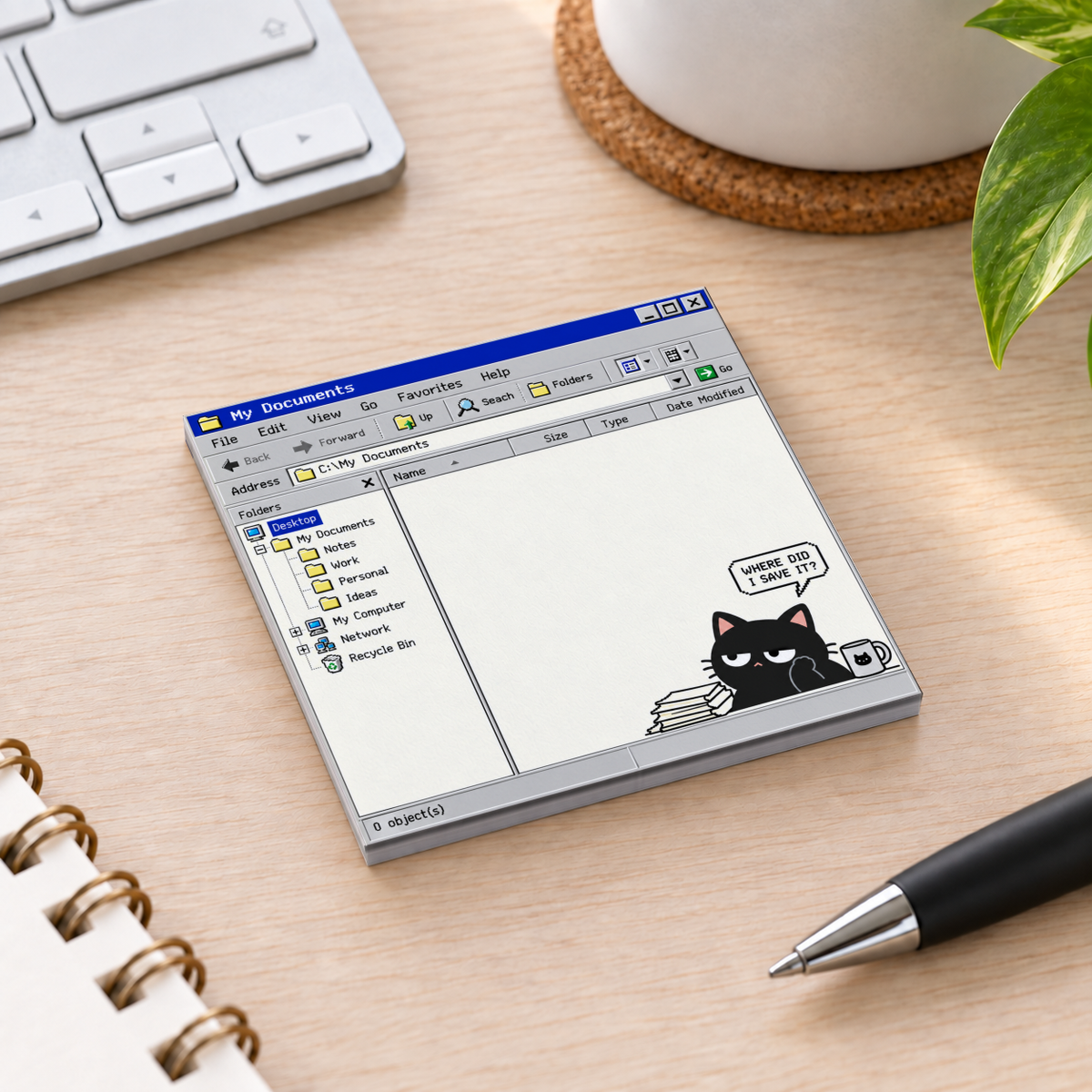 Retro computer black cat sticky note pad on a wooden desk beside a keyboard, pen, and plant.