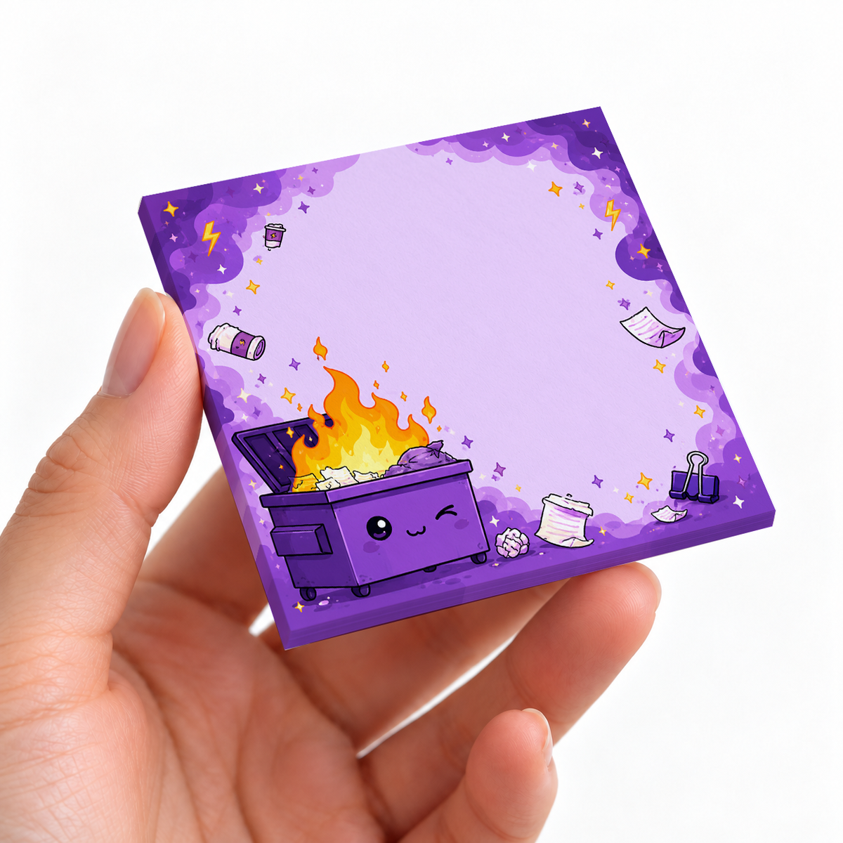 Winking Purple Dumpster Fire sticky note pad on a desk with stationery