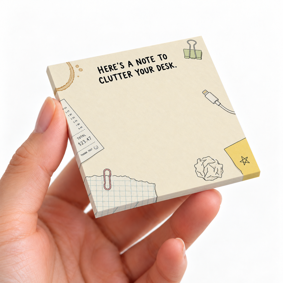 Hand holding a cream Desk Clutter Doodles sticky note pad with office sketches and a blank writing area.