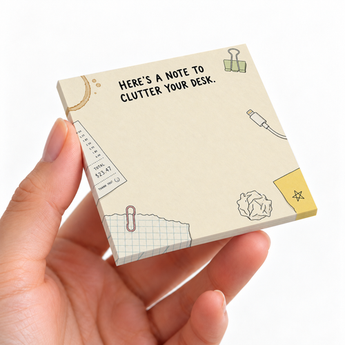 Hand holding a cream Desk Clutter Doodles sticky note pad with office sketches and a blank writing area.