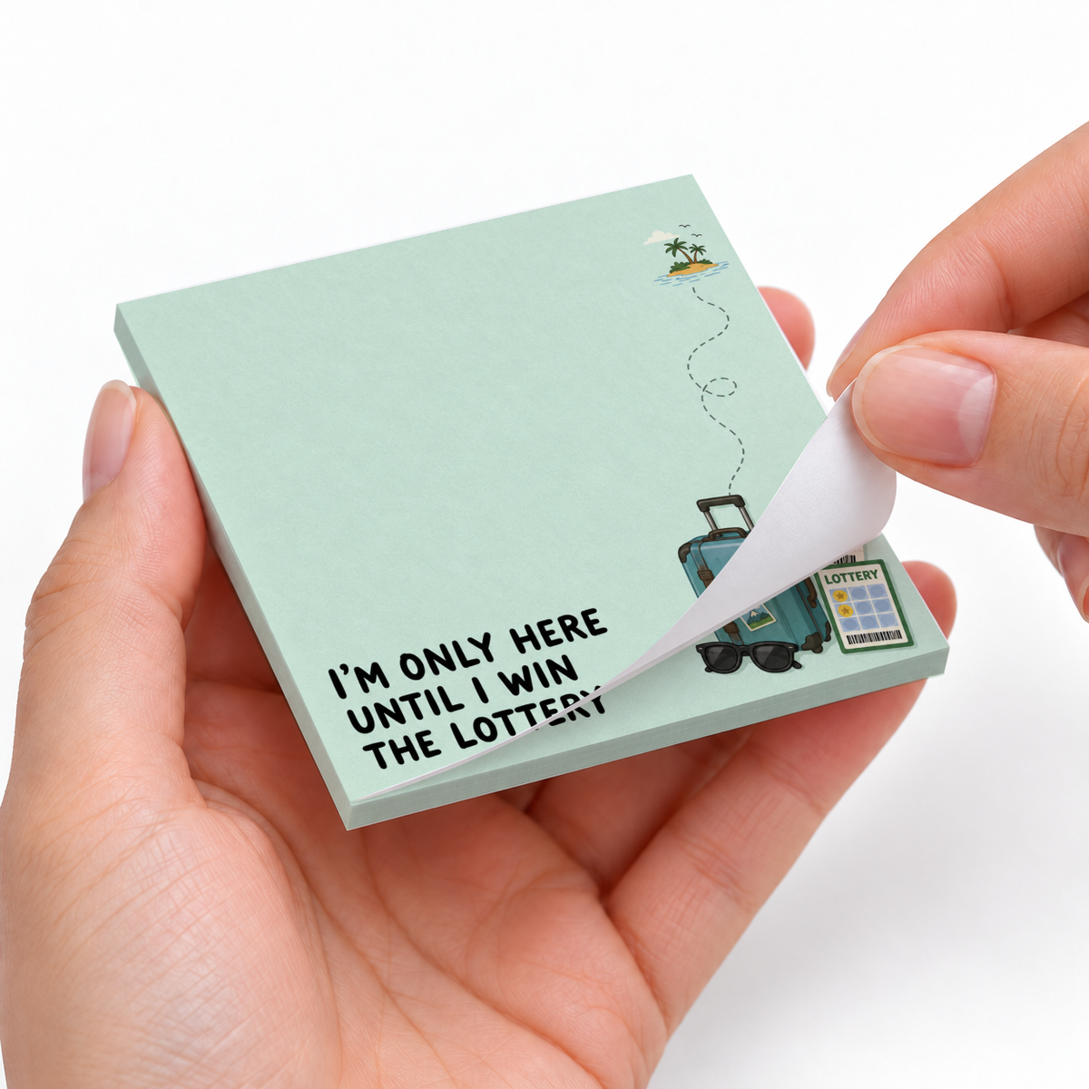 Hands peel a sheet from a mint Lottery Vacation Suitcase sticky note pad with luggage, ticket, and island graphics.